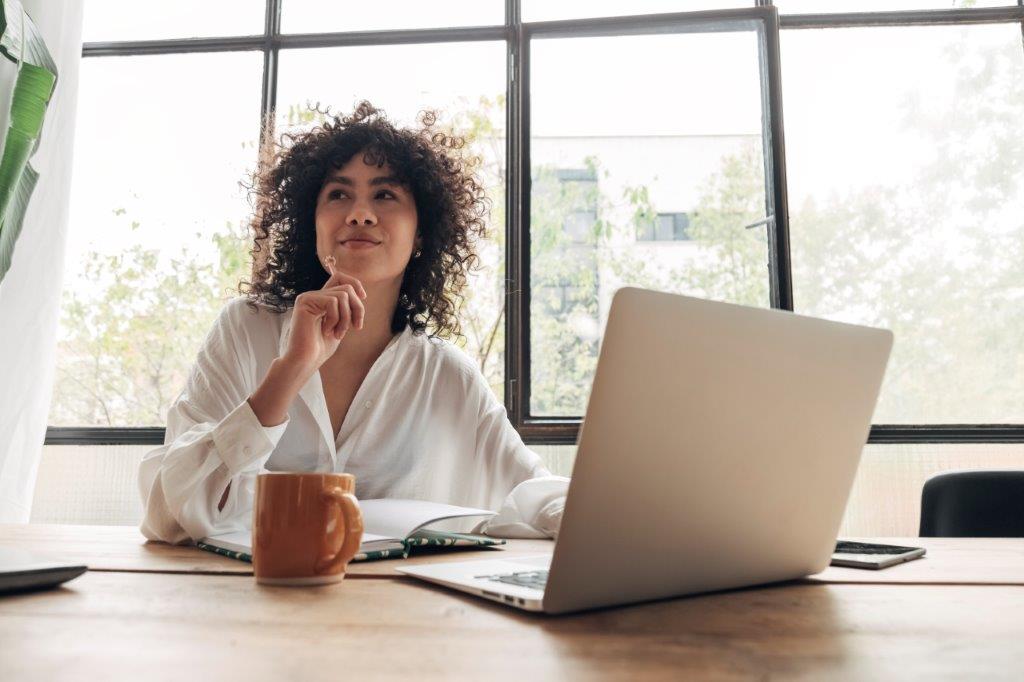 Lady sitting at her desk at work that is happy with her software license